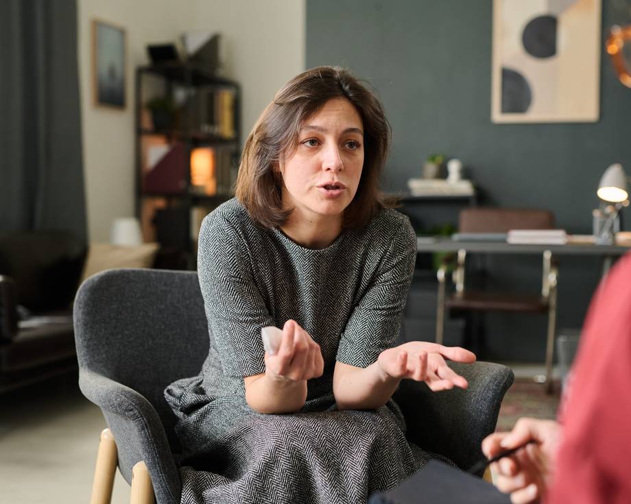 Patientin sitzt auf Couch und spricht über ihre Anliegen