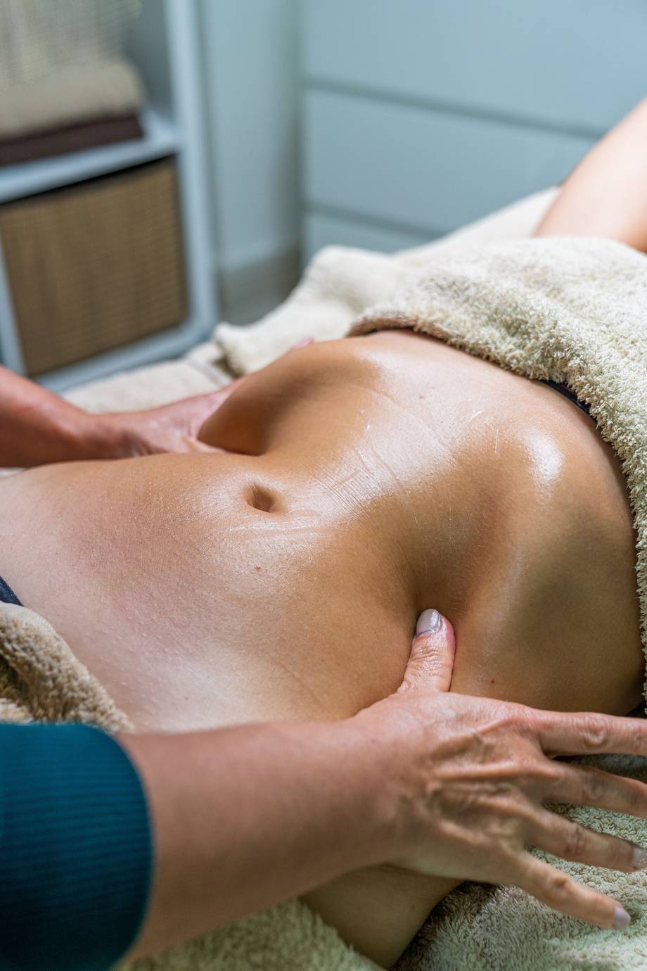 Hände des Spezialisten, der eine Lymphdrainage-Massage am Bauch einer Patientin durchführt.